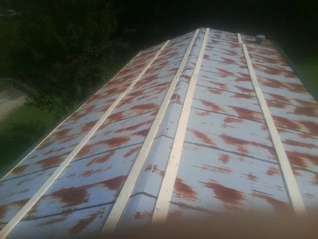 Rusted metal roof panels with new wood purlins before replacement — Storm Damage Roof Repair in Overton by Roofing Brothers