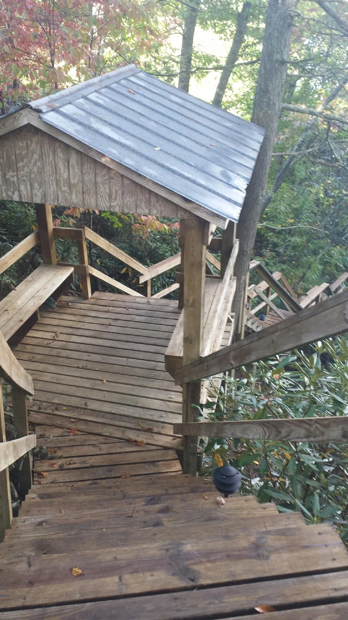 Metal roofed shelter over wooden steps on a wooded walkway — Skylight Repair & Installation work by our crew in Overton