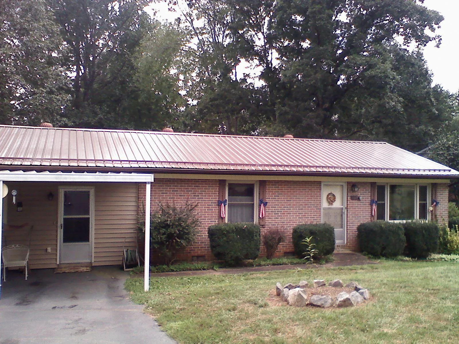 Bronze metal roof and carport on a brick ranch home — Roof Repair work by our crew in Overton
